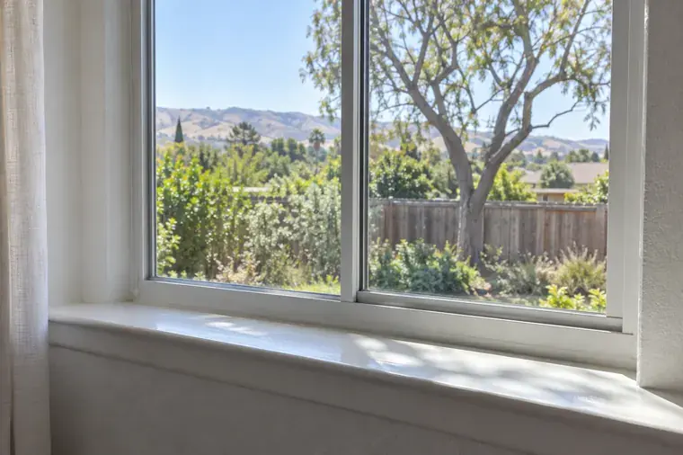 Streak-free window looking out at green foothills